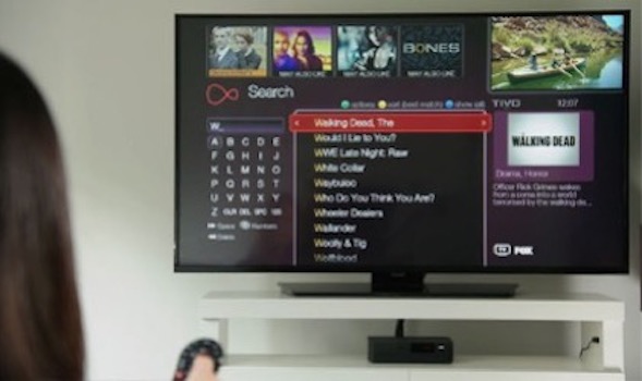 The Virgin Media Digital TV Interface. A lady holds a remote just out of focus.